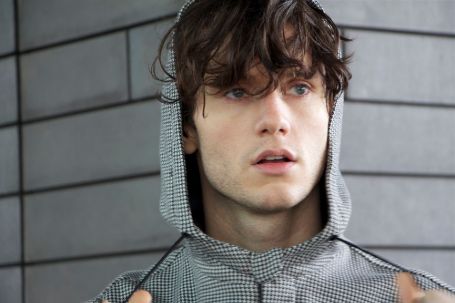 james with messy hair wearing a check hoodie 